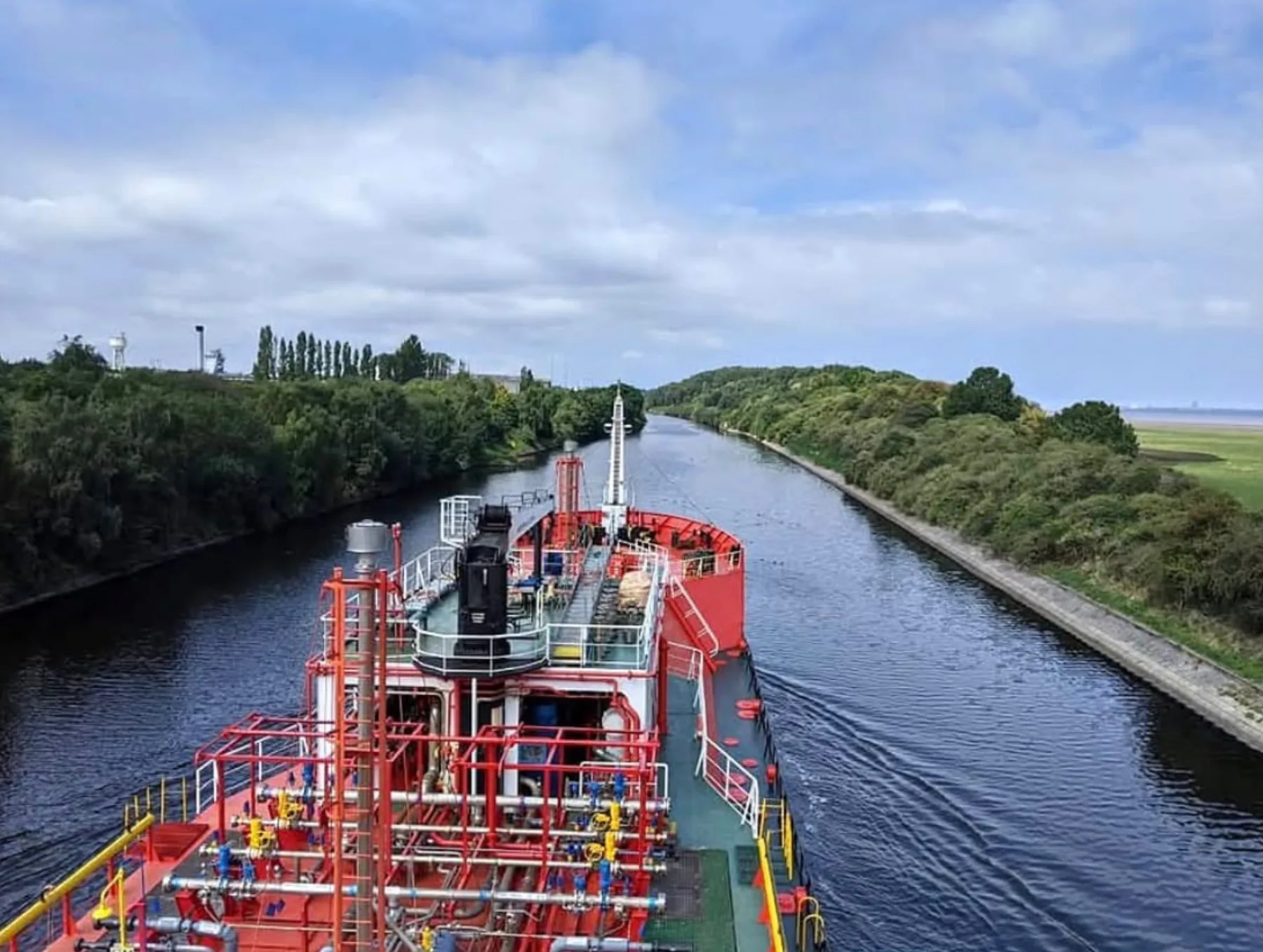 Nave cisterna della flotta in transito lungo un canale navigabile